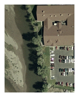 Part of a high-resolution orthophoto showing a stream, trees, building, and a parking lot